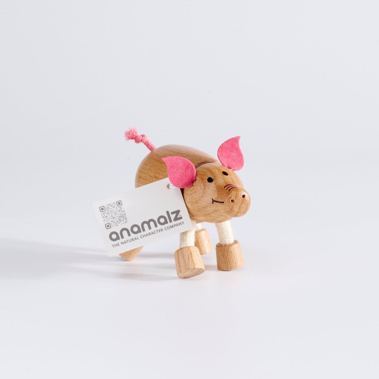 Wooden pig toy with fabric ears and rope tail