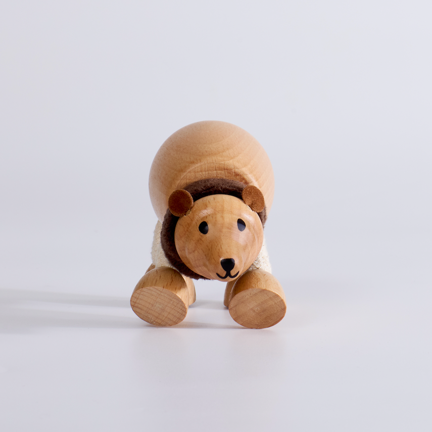 Wooden bear toy with a hat on a white background