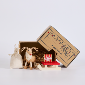 Small decorative reindeer and bag with a cardboard box on a light gray background