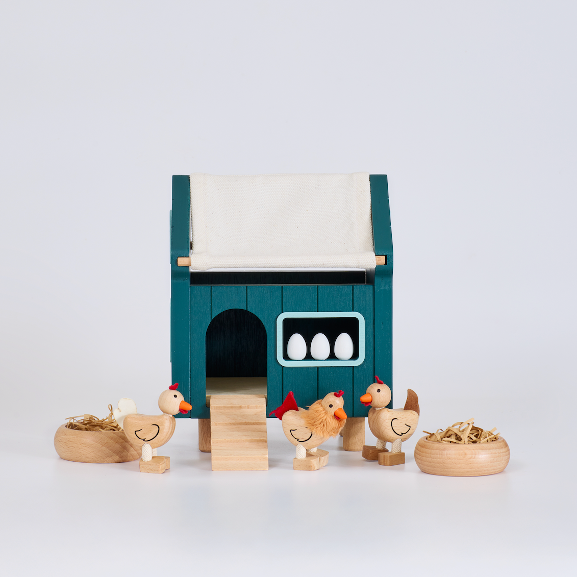 Toy chicken coop with chickens and eggs on a white background